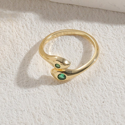Emerald Snake Ring – goldfarbener Schlangenring auf hellem Untergrund