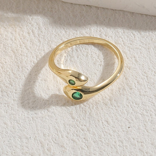 Emerald Snake Ring – goldfarbener Schlangenring auf hellem Untergrund